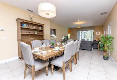 a dining room with a wooden table and chairs at Newly Remodeled 1 story - 5 Bed 5 Bath with Pvt Pool Spa And Game Room in Kissimmee
