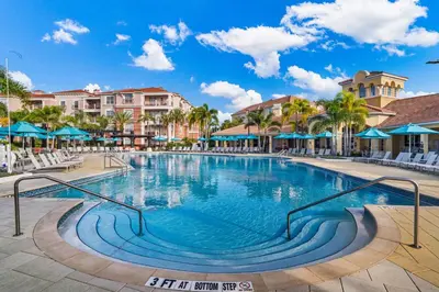 a swimming pool at a resort with chairs and umbrellas at 210 Disney Universal Convention Center in Orlando