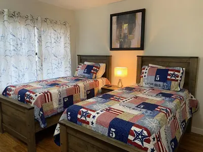 a bedroom with two beds and a table with a lamp at 18-Universal and Heart of International Dr in Orlando