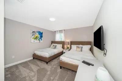 a bedroom with two beds and a flat screen tv at 2705JT LUXURY 7 BED/5 BA (SANITIZED) in Kissimmee