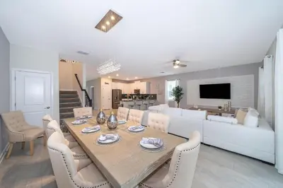 a dining room and living room with a table and chairs at 2705JT LUXURY 7 BED/5 BA (SANITIZED) in Kissimmee