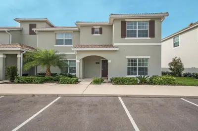 a large house with a parking lot at 3087LL Townhouse 5 Bedrooms & 4 Bathrooms Pool in Kissimmee