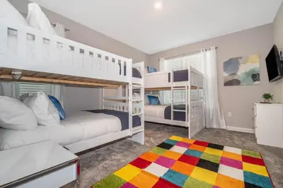 a bedroom with two bunk beds and a rug at 2776LO VILLA 5 BED/5 BA (SANITIZED) in Kissimmee