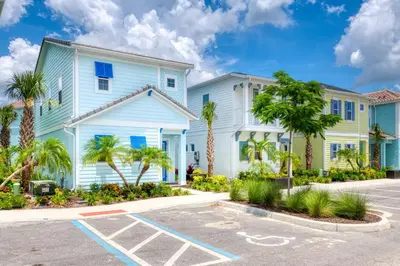 a white house with palm trees in a parking lot at Sandy Shores Cottage Near Disney With Margaritaville Resort & Island H20 Waterpark Access - 2962Sr in Orlando