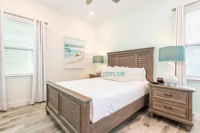 a bedroom with a bed and a table with a lamp at Sandy Shores Cottage Near Disney With Margaritaville Resort & Island H20 Waterpark Access - 2962Sr in Orlando