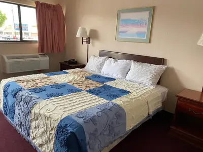 a bedroom with a bed with a blue and white blanket at REGENCY INN in Orlando