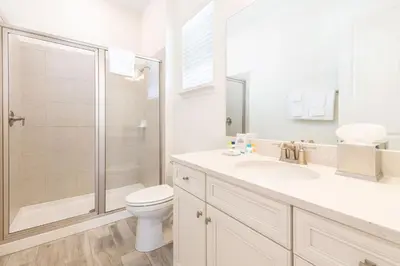 a white bathroom with a toilet and a shower at Blue Shores Cottage Near Disney With Margaritaville Resort & Island H2O Access - 8079Kd in Orlando