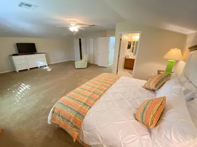 a bedroom with a large white bed with two pillows at Mickeys Corner - Fantastic 5BR with Large Private Garden Pool Hot Tub Game Room Gas BBQ 2 Miles to Disney in Orlando