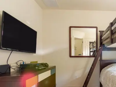 a bedroom with a flat screen tv on a wall at Luxurious With Privacy In 5 Bedroom With Private Pool By Florida Dream Homes in Kissimmee