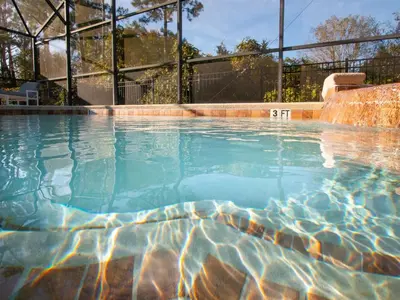 a swimming pool with blue water at 4 Bed And 3 Bath In Perfect Location With Pool By Florida Dream Home in Kissimmee