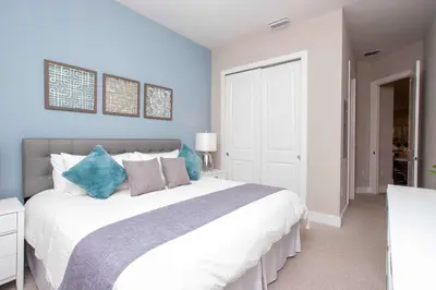 a bedroom with a large bed with blue walls at Gorgeous 4 Bedroom Family Friendly Close to Disney 7573 in Orlando