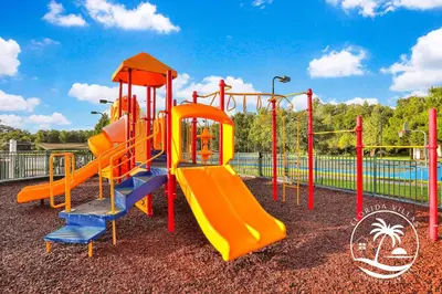 a playground with an orange and blue slide at Villas at Seven Dwarfs - Close to Disney in Kissimmee