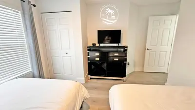 a bedroom with a bed and a tv on a dresser at Villas at Seven Dwarfs - Close to Disney in Kissimmee