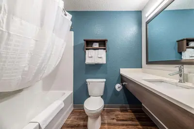 a bathroom with a toilet and a sink and a tub at WoodSpring Suites Sanford North I-4 Orlando Area in Sanford