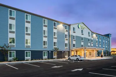a hotel with a car parked in a parking lot at WoodSpring Suites Sanford North I-4 Orlando Area in Sanford