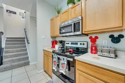 a kitchen with a stove and a microwave at 8 Mi to Disney Villa with Screened Pool and Lanai in Kissimmee