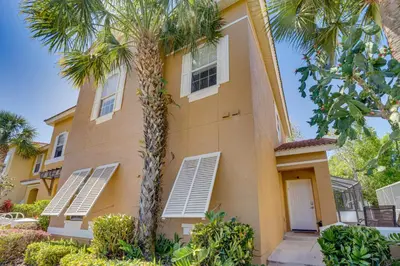 a building with palm trees in front of it at 8 Mi to Disney Villa with Screened Pool and Lanai in Kissimmee