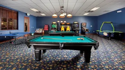 a room with two pool tables and arcade games at Resort Retreat in Kissimmee