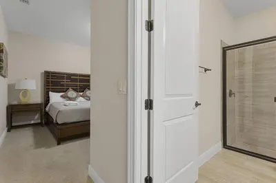 a bedroom with a bed and a glass door at 520-IBRAHIM · 520 - 8BD Home PoolSpa - MovieGame room in Orlando