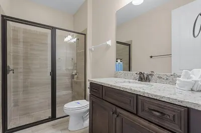 a bathroom with a toilet and a sink and a shower at 520-IBRAHIM · 520 - 8BD Home PoolSpa - MovieGame room in Orlando