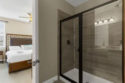 a bedroom with a glass shower and a bed at 520-IBRAHIM · 520 - 8BD Home PoolSpa - MovieGame room in Orlando