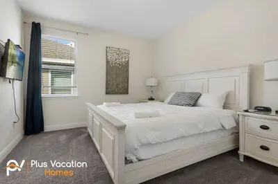 a white bedroom with a large bed and a window at 331 Villa SpaPool- GamesTheater by Disney in Orlando