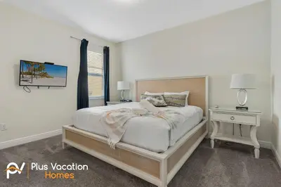 a white bedroom with a bed and a night stand at 331 Villa SpaPool- GamesTheater by Disney in Orlando