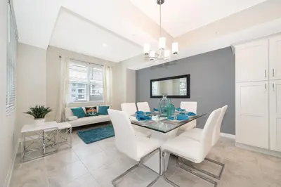 a dining room with a glass table and white chairs at 3180-202BV STOREY LAKE, CONDO 2/2 GARDEN VIEW in Kissimmee
