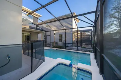 an indoor swimming pool in a house with glass walls at 2741MA VILLA 5 BED/5 BA (SANITIZED) in Kissimmee
