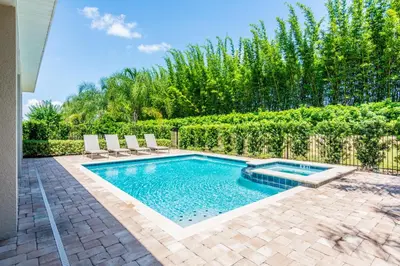 a swimming pool with chairs and a fence at Gorgeous Single Home with Private Pool at Encore in Orlando