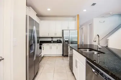 a kitchen with white cabinets and a stainless steel refrigerator at Gorgeous Single Home with Private Pool at Encore in Orlando