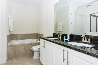 a bathroom with two sinks and a tub and a toilet at Gorgeous Single Home with Private Pool at Encore in Orlando