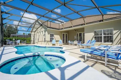 a swimming pool with blue chairs and a patio at Mickeys Floridian - Glorious 5BR Private South Facing Pool Hot Tub Game RM GYM BBQ - 2 miles to Disney in Orlando