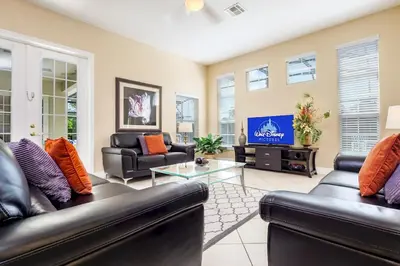 a living room with two leather couches and a tv at Mickeys Floridian - Glorious 5BR Private South Facing Pool Hot Tub Game RM GYM BBQ - 2 miles to Disney in Orlando