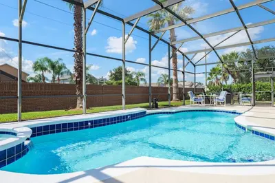 a swimming pool with a pergola next to a house at Mickeys Floridian - Glorious 5BR Private South Facing Pool Hot Tub Game RM GYM BBQ - 2 miles to Disney in Orlando