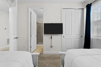 a bedroom with two beds and a tv on the wall at 320 Pet Friendly 6BD Villa - PoolSpa in Orlando