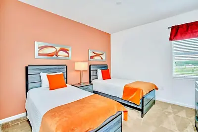 two beds in a room with orange and white at Family Resort - 6BR Mansion - Private Pool, Home Theater, BBQ and More in Kissimmee