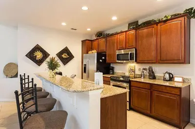 a kitchen with wooden cabinets and a counter top at bsv_villa7747 in Orlando