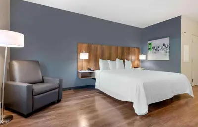 a bedroom with a large bed and a chair at Extended Stay America Premier Suites - Orlando - Sanford in Sanford