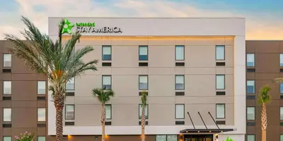 a hotel with palm trees in front of a building at Extended Stay America Premier Suites - Orlando - Sanford in Sanford