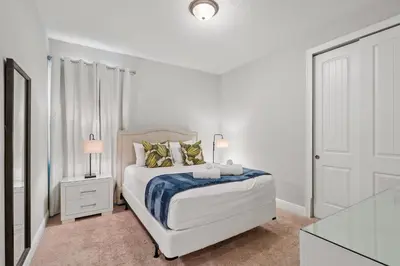 a white bedroom with a white bed and a window at Encore Resort 6 Bedroom Home with Pool 2301 in Orlando