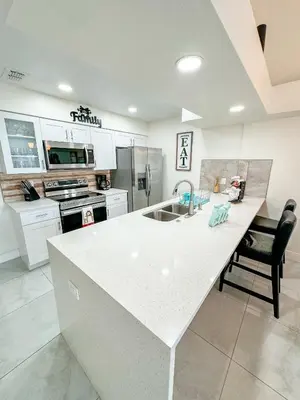 a kitchen with a white counter top and a sink at ELEGANT & LUXURIOUS FAMILY APARTMENT close to DISNEY WORLD in Kissimmee