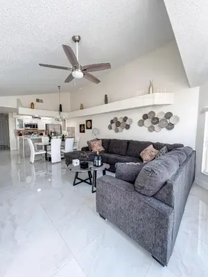 a living room with a couch and a ceiling fan at ELEGANT & LUXURIOUS FAMILY APARTMENT close to DISNEY WORLD in Kissimmee