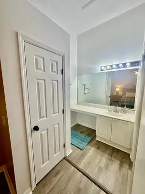 a bathroom with a tub and a sink and a door at Grand Holiday 3BR Palms Condo near Disney Parks in Kissimmee