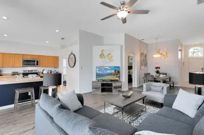 a living room with a couch and a kitchen at Immaculate 4 bedrooms 3 bathroom in Windsor Palms villa in Kissimmee