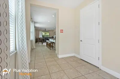 a hallway with a white door and a dining room at 7541 Huge 8BD Home - POOLSpa - GameMovie room in Orlando