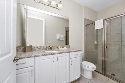 a white bathroom with a toilet and a shower at Gleaming Home With Private Pool, Theater Room And Water Park Access Near Disney At Encore Resorts Reunion - 209Sf in Kissimmee
