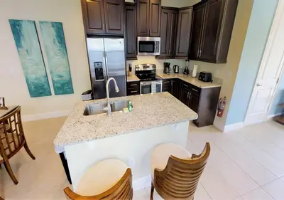 a kitchen with a sink and a counter with chairs at 7613-IBRAHIM · 7613 Paradise at Encore wiith Private pool in Orlando