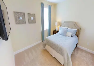 a white bedroom with a bed and a television at 7613-IBRAHIM · 7613 Paradise at Encore wiith Private pool in Orlando