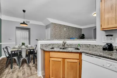 a kitchen with a sink and a table with chairs at 2 Bedroom Vacation Condo 2016 in Kissimmee